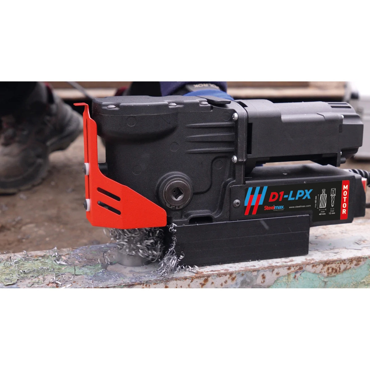 Steelmax 115V D1 LPX Magnetic Drill in action, drilling a beam and producing spiraling metal shavings up close.