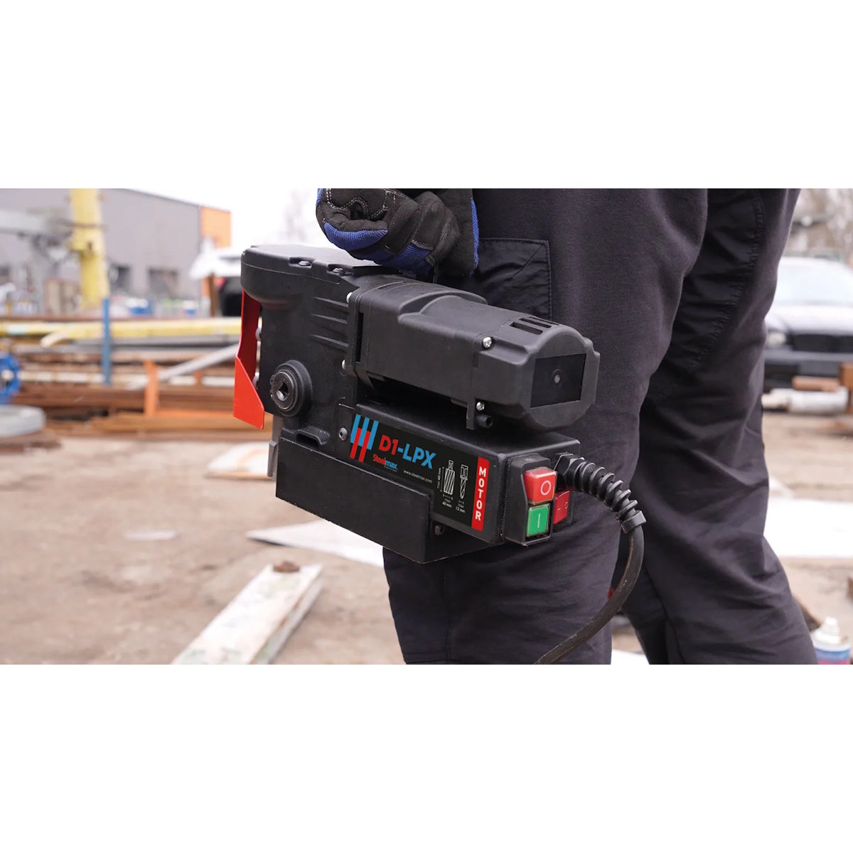 Steelmax 115V D1 LPX Low Profile Portable Magnetic Drill in use by worker at outdoor construction site.