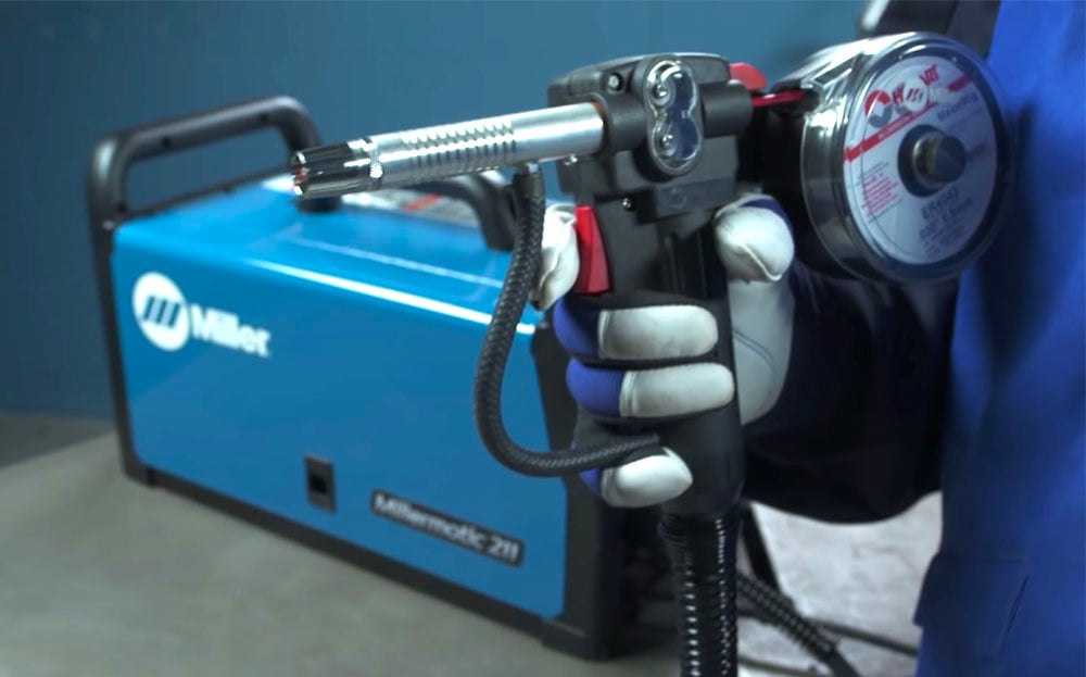 Miller spool gun mounted on a blue MIG welder