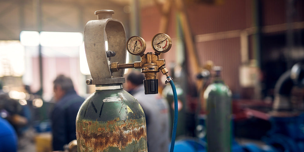 Compressed gas cylinder with a two-gauge regulator in a welding shop