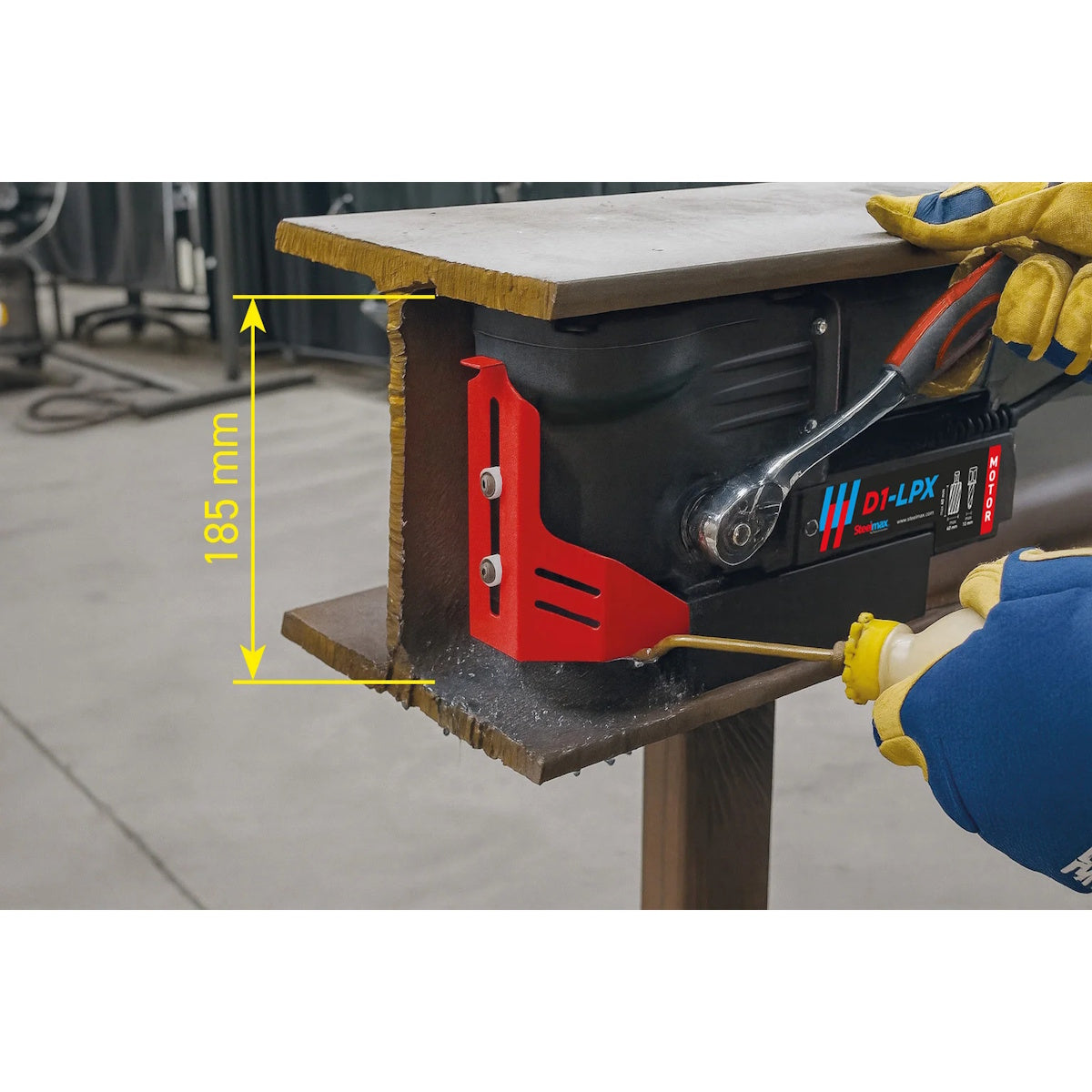 Steelmax 115V D1 LPX Mag Drill in use by a gloved operator on a steel beam marked at 185 mm.